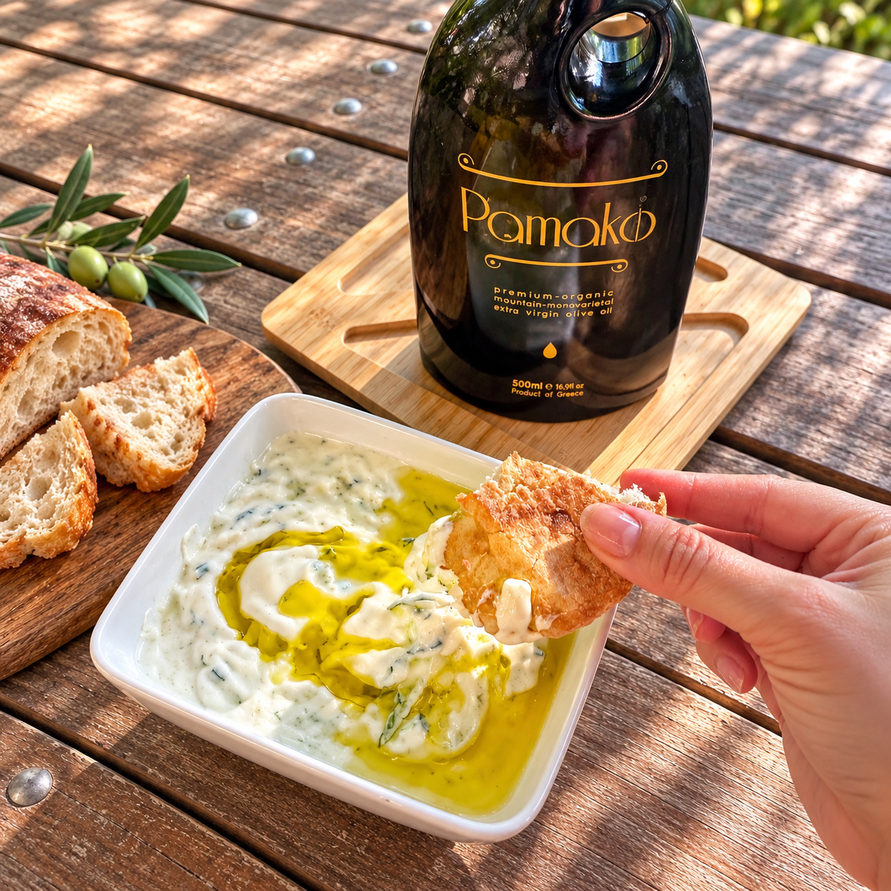 Authentic Cretan tzatziki drizzled with Pamako extra virgin olive oil, served with rustic bread on a wooden table.