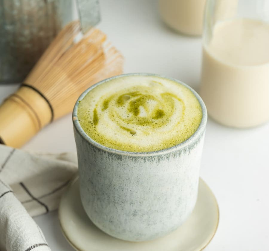 Whisked organic matcha latte in a cup – natural energy boost and focus-enhancing superfood.
