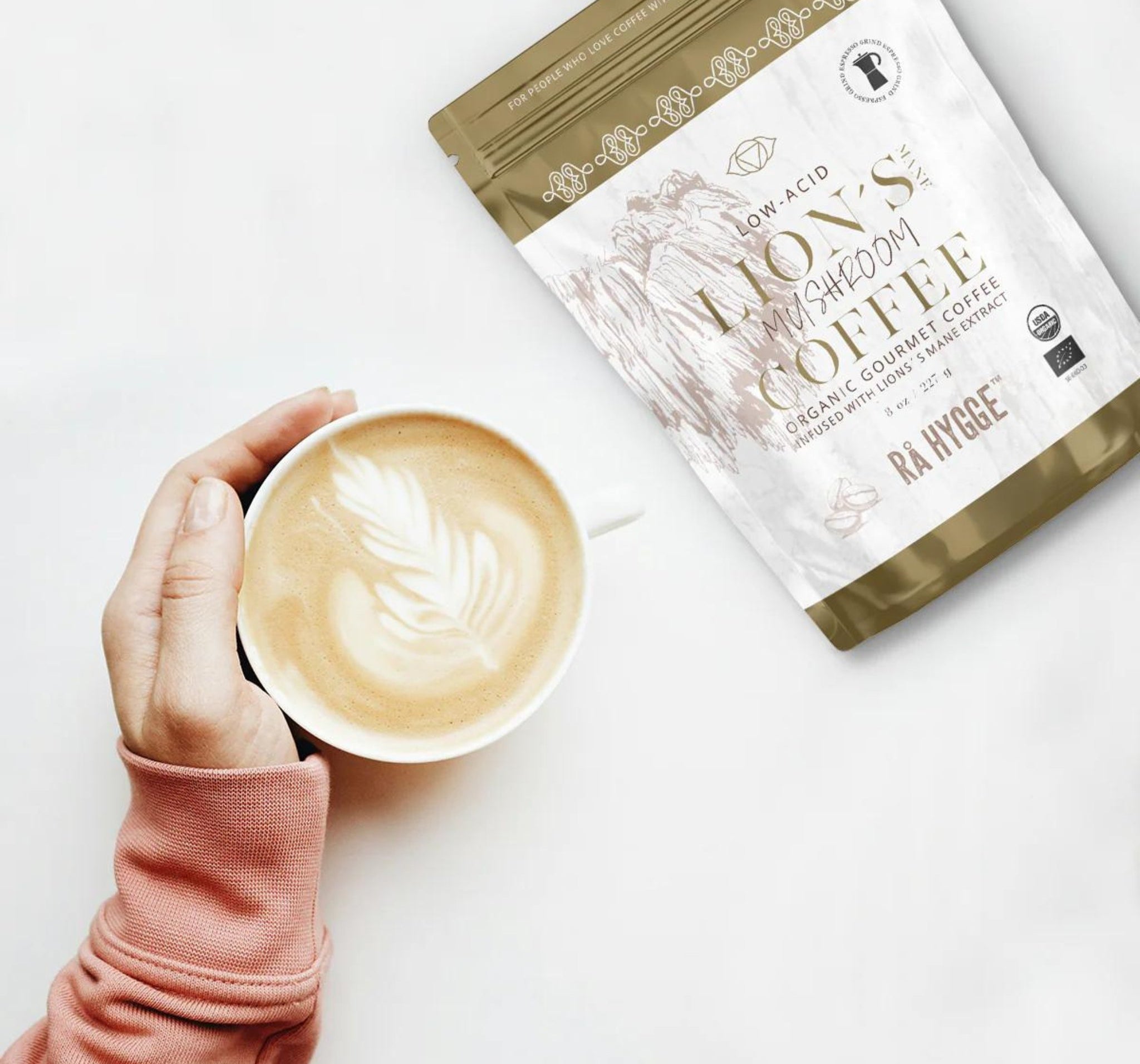 A cup of coffee next to the Organic Lion’s Mane mushroom coffee package.