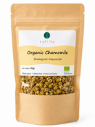 A 20g stand-up pouch of Tofillo Organic Chamomile herbal tea. The packaging is made of brown kraft paper with a white and yellow label, and a clear window at the bottom showing the dried chamomile flowers inside.